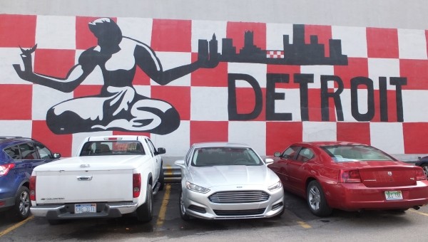 drei Autos vor einer Wand mit der Aufschrift Detroit
