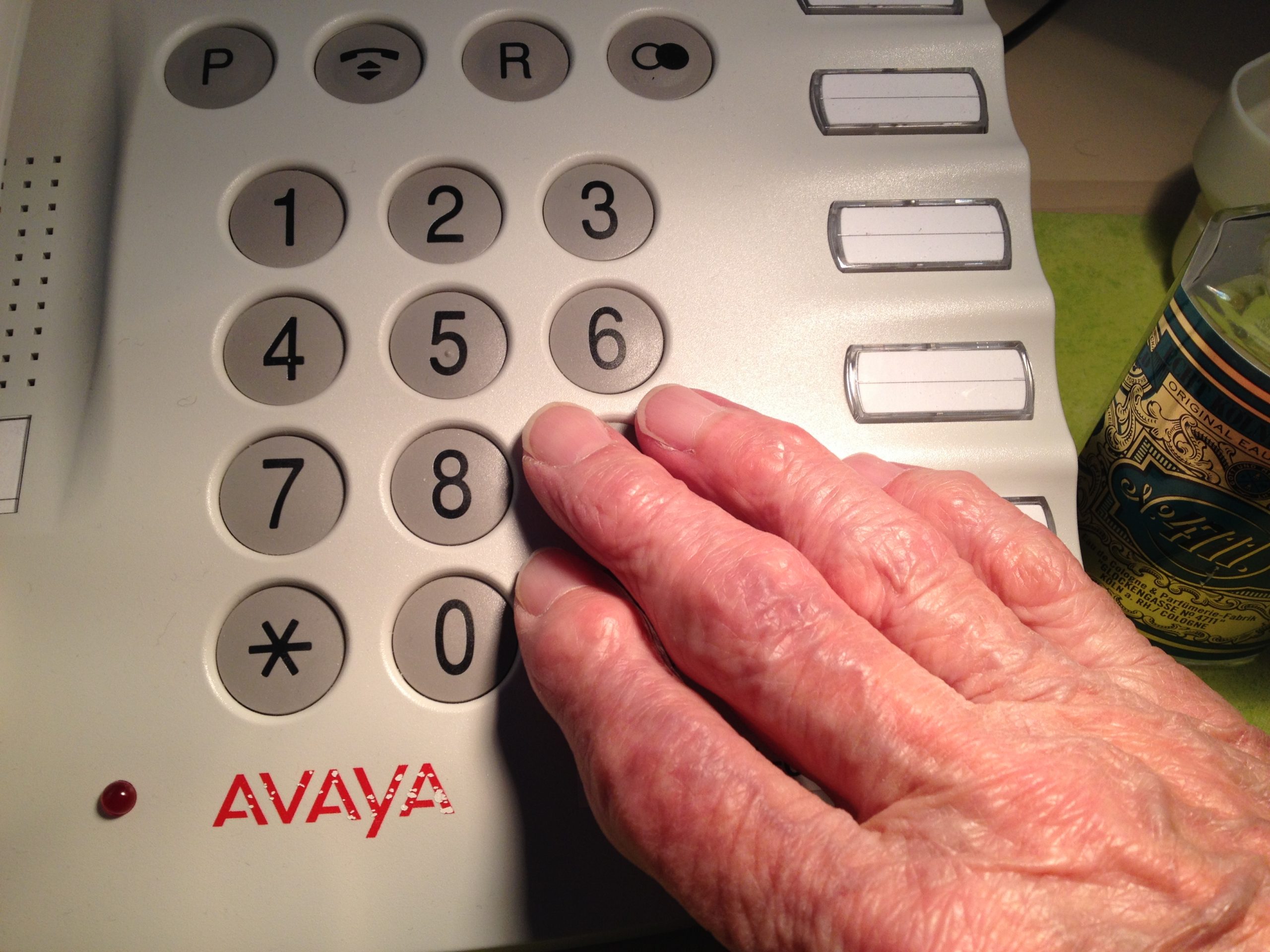 Das Foto zeigt eine seniorengerechtes Telefon, im Vordergrund die Hand einer offensichtlich älteren Person.