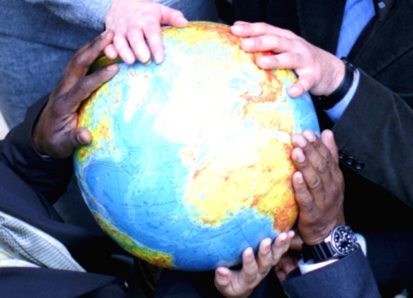 Verschiedene Mitarbeiter mit einem Globus in ihren Händen