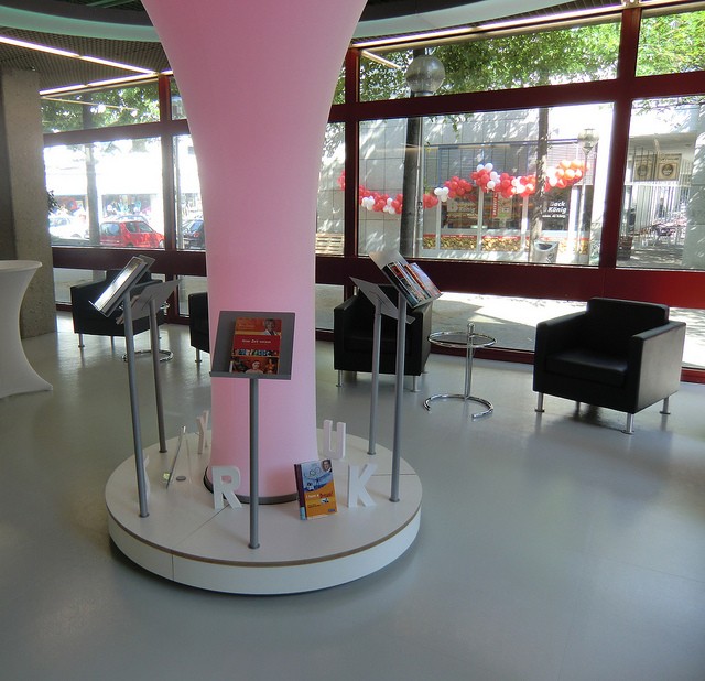 Leseraum in der Stadtbibliothek Köln. Einige Sessel und in der Mitte eine rosa leuchtende Säule mit Tablets auf Ständern drum herum