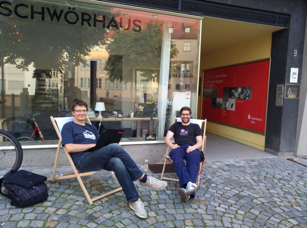 Stefan Kaufmann und Mario Wiedemann vor dem Verschwörhaus, in Liegestühlen sitzend