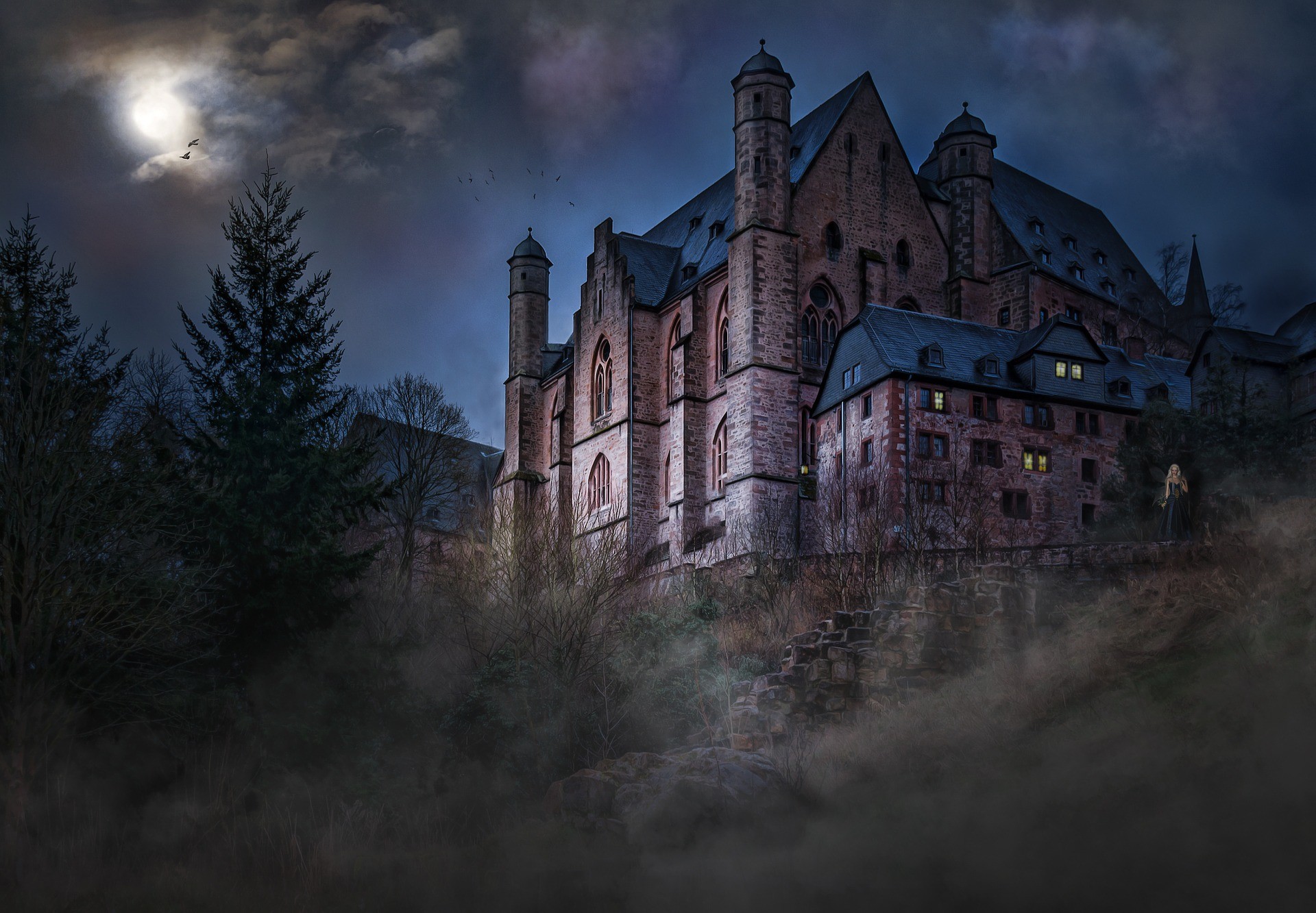 Blick auf eine Burg in der Nacht. Im Hintergrund strahlt der Vollmond.